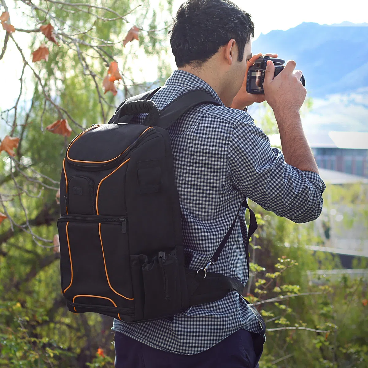 USA Gear Sac à Dos Appareil Photo Réflex Numérique avec Support Trépied, Compartiment Ordinateur Portable et Rangements Accessoires - Sac Photo Compatible avec Canon, Nikon, Pentax et Plus - Orange